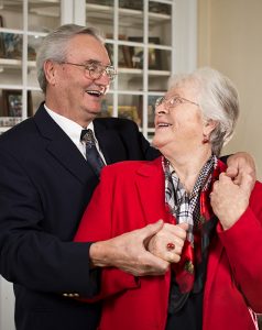 photo of elderly couple holding hands and looking at each other