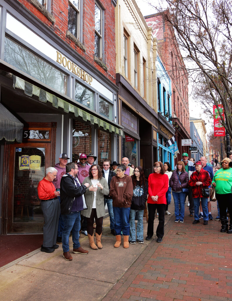 A crowd gathers on Main Street in Danville, Virginia, as the new owners of The Dogeared Page Bookshop stand with local dignitaries during the ribbon-cutting ceremony at the store’s grand reopening.